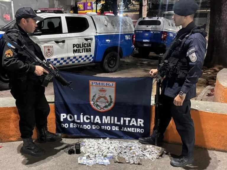 Policiais militares exibem drogas, rádio comunicador e dinheiro apreendidos em operação no Fonseca, Niterói.