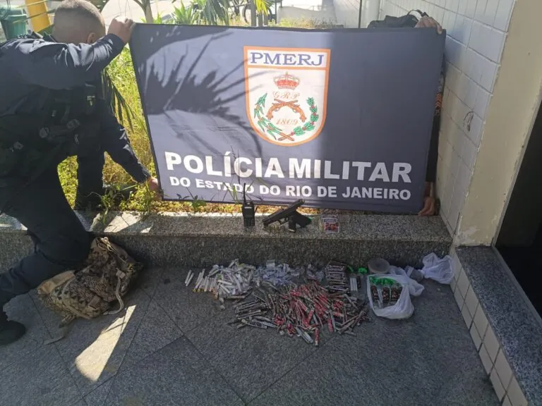 Policiais militares em operação com material apreendido, como arma, drogas e moto, em São Gonçalo.