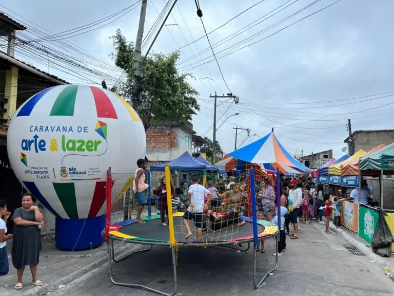 Crianças brincando em pula-pula e escorrega inflável durante a Caravana de Arte e Lazer em São Gonçalo.