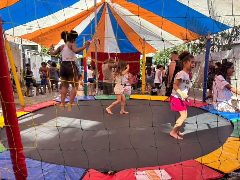 Crianças brincam em pula-pula e brinquedos infláveis em evento da Caravana de Arte e Lazer em São Gonçalo.