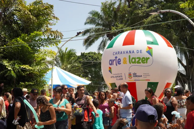 Crianças brincando em cama elástica e infláveis em evento de lazer ao ar livre em São Gonçalo.