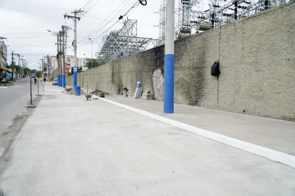 Obras de urbanização na entrada do Jardim Catarina, São Gonçalo, com trabalhadores e máquinas.