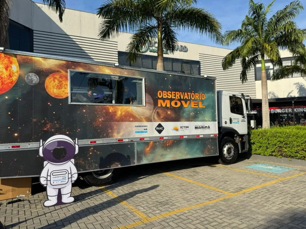Telescópio apontado para o céu em evento de observação astronômica em Maricá com crianças.