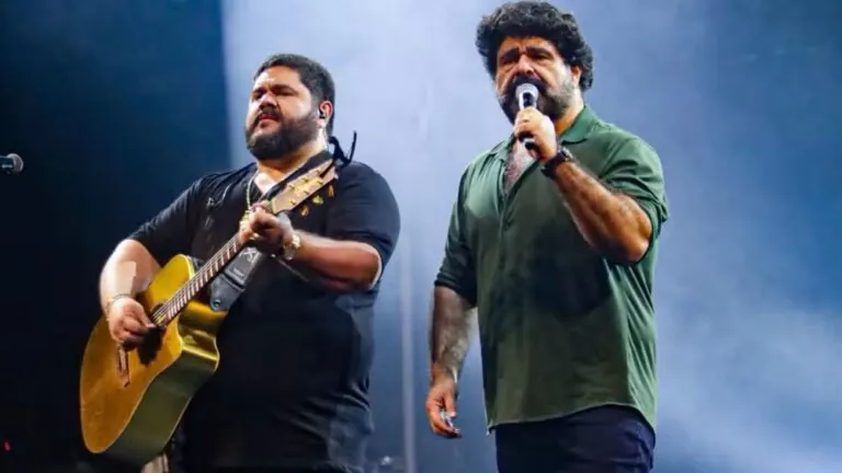 César Menotti e Fabiano cantam no palco da Expo Rural Maricá, com luzes e público ao fundo.