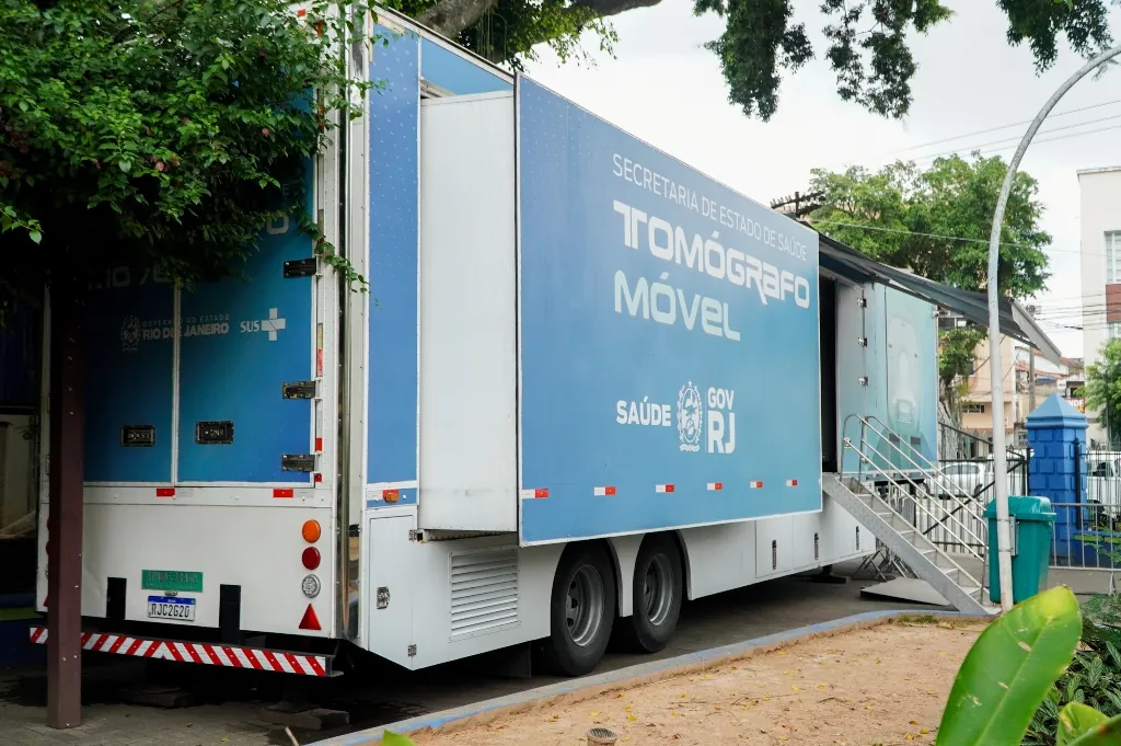 Carreta de tomografia computadorizada estacionada na Praça Zé Garoto em São Gonçalo, com pacientes aguardando atendimento.